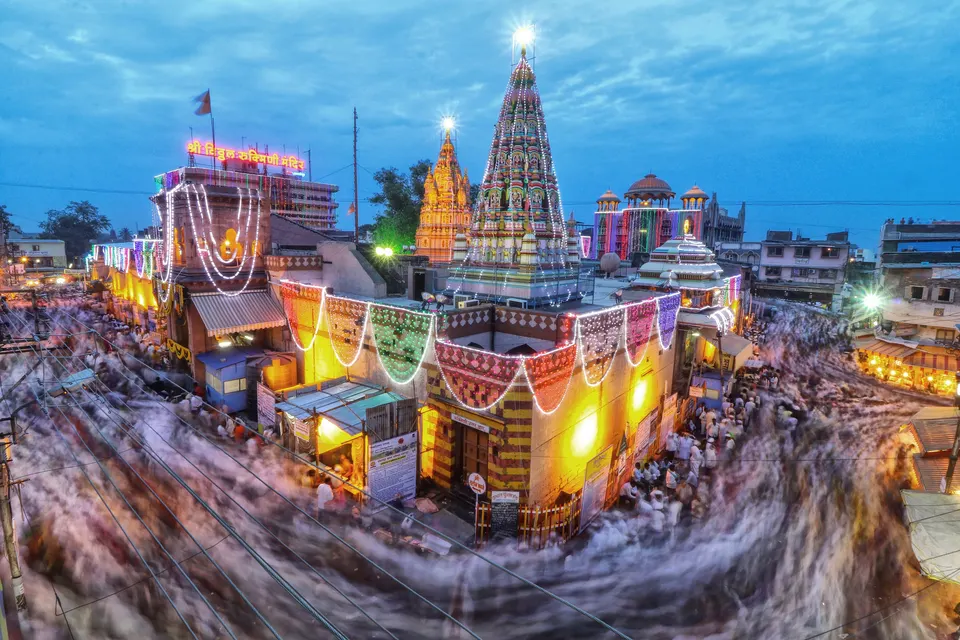 रोषणाईने उजळलेले पंढरपूरचे श्री विठ्ठल रुक्मिणी मंदिर आणि भोवतीच्या रस्त्यांवरून जाणारी भाविकांची गर्दी