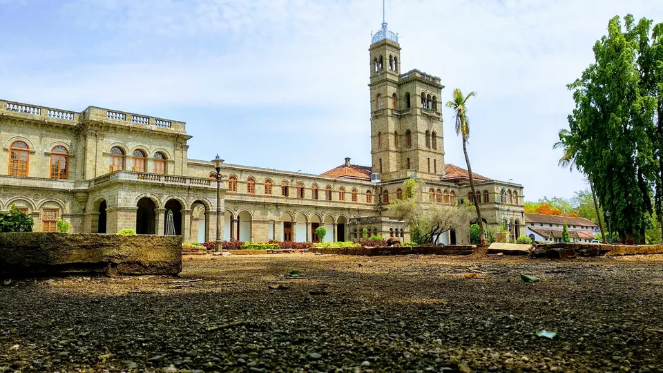 The stone main building of Savitribai Phule Pune University with its clock tower