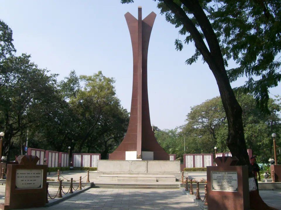 पुण्यातील दक्षिण मुख्यालयाच्या राष्ट्रीय युद्ध स्मारकाचा उंच लाल स्तंभ आणि भोवतालची झाडी