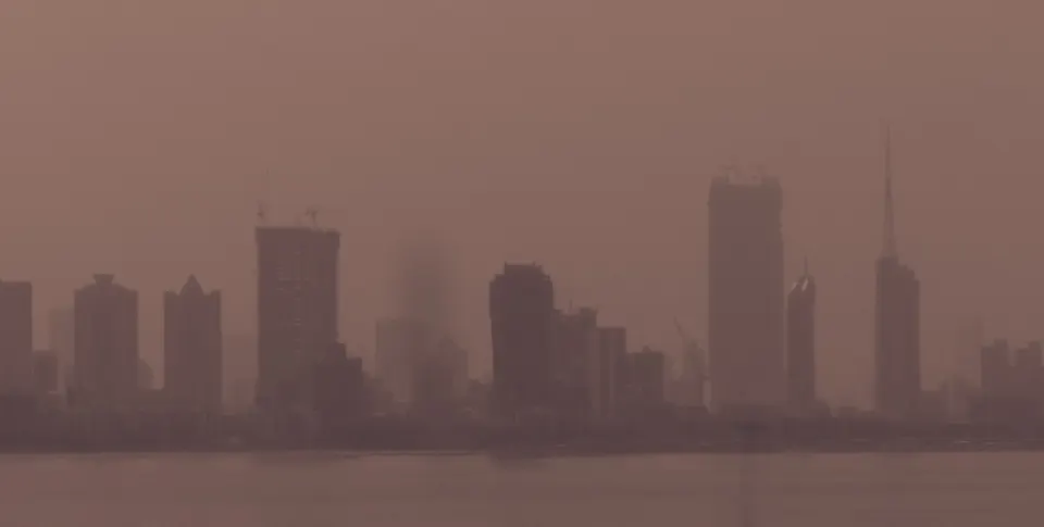 Mumbai high-rises across the water, blurred by haze
