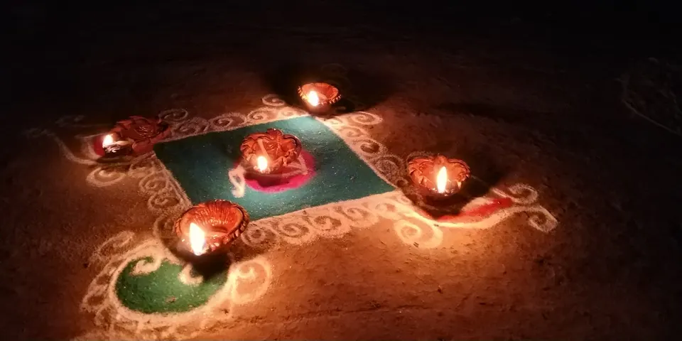 Lit clay diyas placed on a rangoli