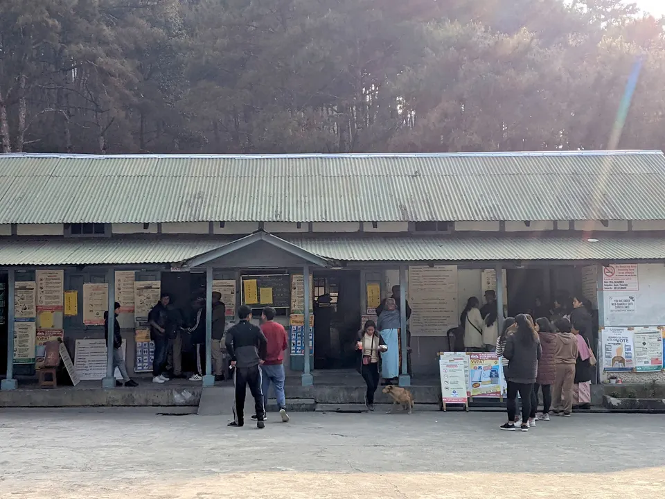 मतदान केंद्राबाहेर उभे नागरिक