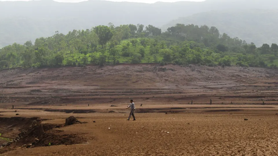 पाणी आटल्याने उघडे पडलेले धरणाचे पात्र